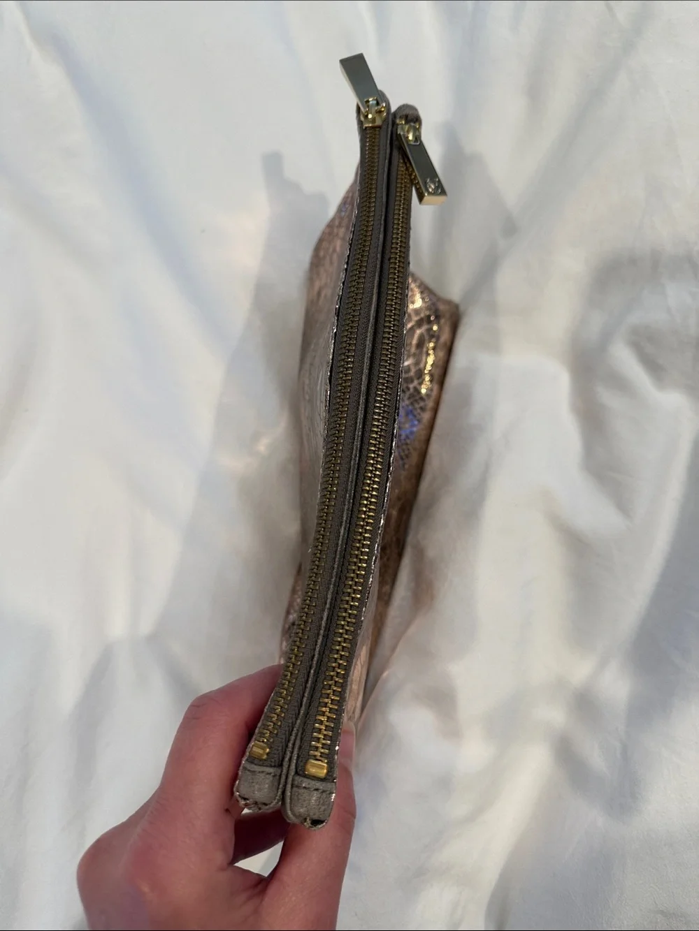 Leather Zip reversible clutch in Metallic taupe and reverses to rose gold